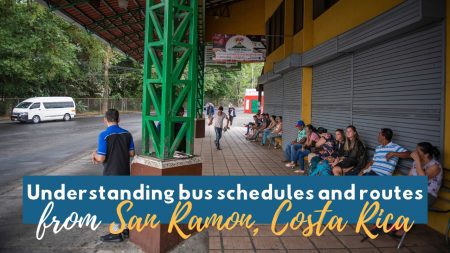 People waiting at the San Ramon bus terminal in Costa Rica with green metal beams and yellow building exterior